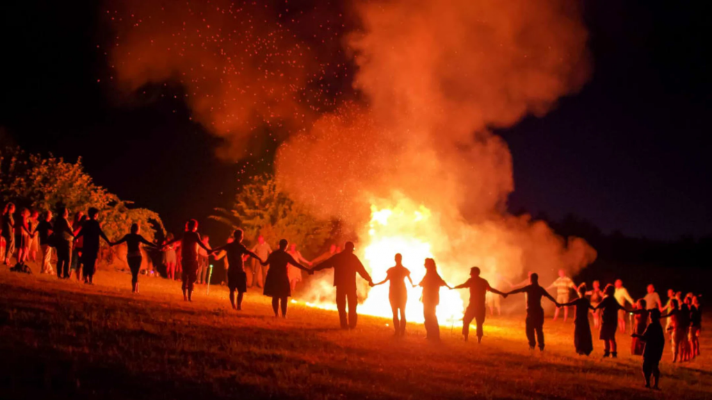 People dancing around a bonfire celebration at Samhain.