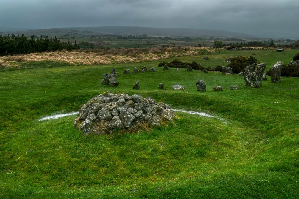An Early Bronze Age cairn surrounded by a trench (partly filled with water from a recent rainfall) near a Stone Circle at the Beaghmore complex archaeological site, County Tyrone, Northern Ireland.